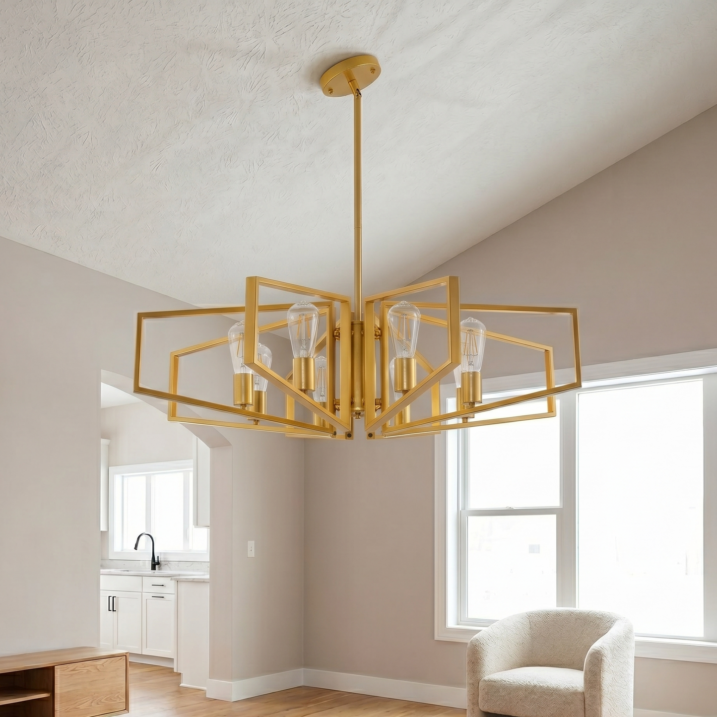 Gold chandelier hanging in a room with neutral walls and a window.