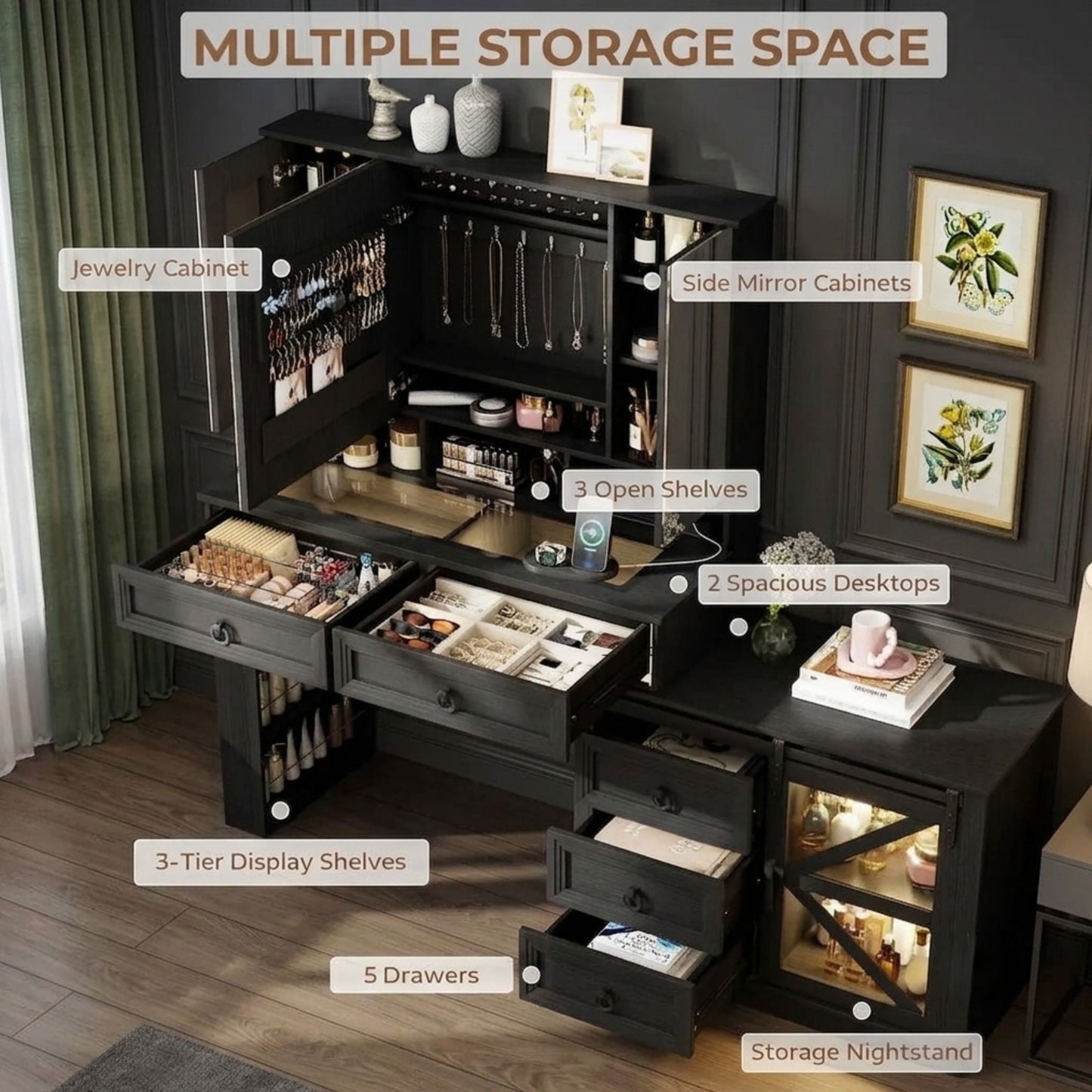 A black multiple-storage vanity desk shown open in a styled room, with labeled callouts pointing to jewelry cabinets, side mirror cabinets, open shelves, desktops, tier display shelves, drawers, and a storage nightstand. The room has dark paneled walls, wood flooring, curtains, and framed wall art.