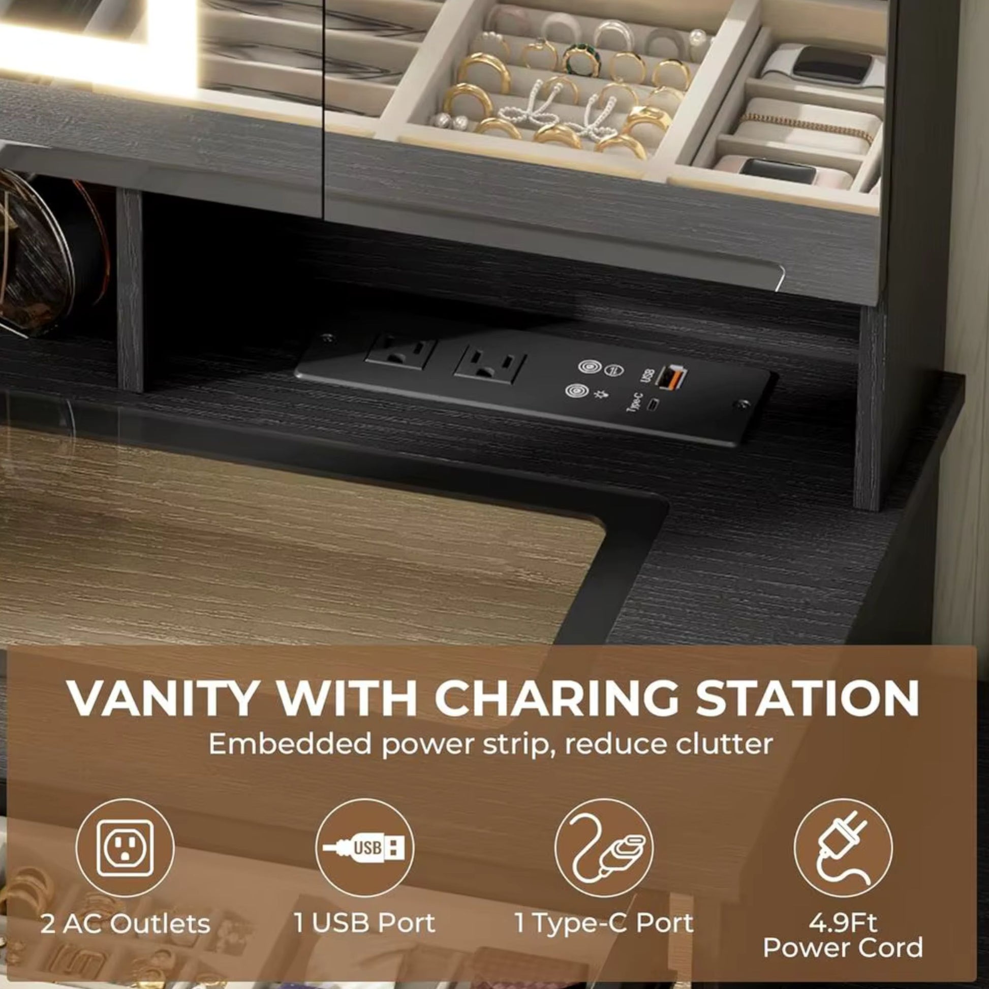A close-up of a dark wood vanity cabinet with built-in charging station features, including an embedded power strip with USB ports and a power cord. The top shelf holds organized jewelry and accessories.