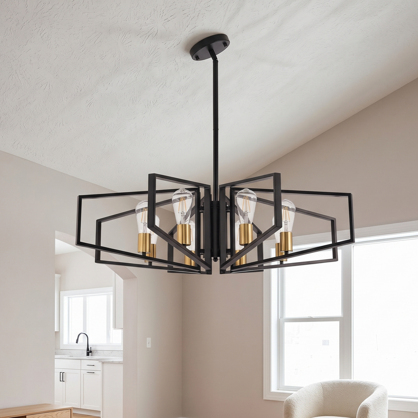 Modern black chandelier hanging in a room with neutral walls and a window.